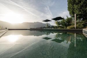 - une piscine avec des parasols dans l'établissement Ansitz Romani, à Termeno