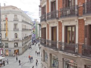 Un groupe de personnes marchant dans une rue de la ville dans l'établissement Enorme y acogedor piso en la puerta del sol, à Madrid