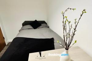 a bedroom with a bed and a table with a vase at The Purple 5 Bedroom House By AltoLuxoExperience Short Lets & Serviced Accommodation With Free Parking in Bristol