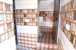 Habitación con espejo y pared de azulejos. en OYO Shiv guru guest house en Bodh Gaya