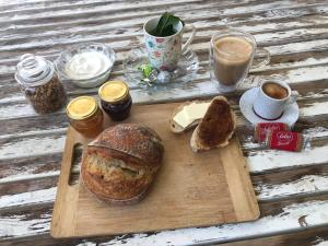 una tabla de cortar de madera con pan y tazas de café en Bed & Bread en Chorazim