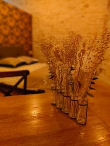vier glazen vazen gevuld met gedroogde bloemen op een tafel bij Chamade en Beaujolais in Anse
