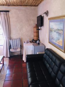 a living room with a couch and a table at Wild Rose Country Lodge in Noordhoek