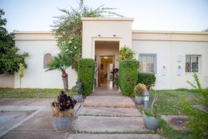 a white building with a door and some plants at ROYAL GOLF DE FES in Fez