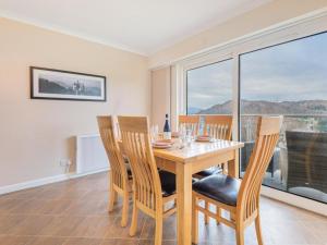une salle à manger avec une table, des chaises et une grande fenêtre dans l'établissement 2 Bed in Ambleside SZ041, à Ambleside