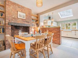 a kitchen with a table and chairs and a brick wall at 3 Bed in Backbarrow SZ549 in Backbarrow