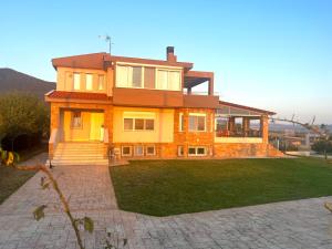 a large house with a lawn in front of it at Hillside View Villa in Thermi