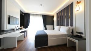 アンタルヤにあるMai İnci Otelのベッドとテレビが備わるホテルルームです。