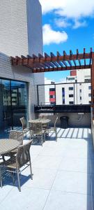 a patio with tables and chairs on top of a building at Summer Flat Ap308 Intermares in Cabedelo