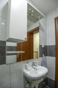 y baño con lavabo y espejo. en Elena Apartments - City Center Oasis Modern Elegance in Skopje, en Skopje
