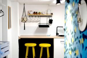 a kitchen with two yellow stools next to a counter at Gemütliche Souterrain Wohnung in Lüneburg