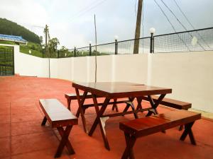 een picknicktafel en twee banken op een patio bij Munnar Valley View in Munnar