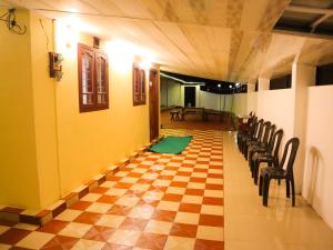 un corridoio con sedie e un pavimento a scacchi di Munnar Valley View a Munnar Altre 21 foto