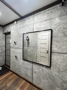 een spiegel aan de muur van een kamer met een deur bij Квартира с авторским дизайном in Karagandy