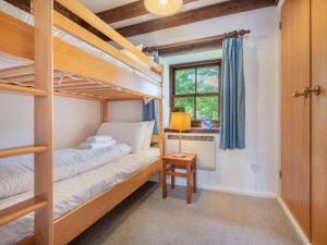 a bedroom with two bunk beds and a desk at 2 Bed in Mosedale SZ218 in Mosedale