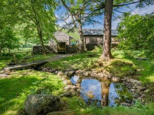 a house with a tree and a pond in the yard at 2 Bed in Mosedale SZ218 in Mosedale