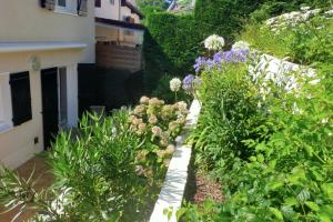 House with garden in Biarritz - quiet area في بياريتز: حديقة بها زهور ونباتات بجوار مبنى