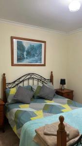 Un dormitorio con una cama grande con almohadas. en Q’s Home Stay, en Claremont