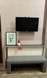 a santa claus doll sitting on a bench under a tv at Chikhi in Tbilisi City