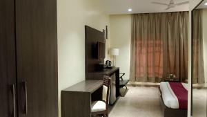 een hotelkamer met een slaapkamer met een bed en een bureau bij VEENA REGENCY in Chās