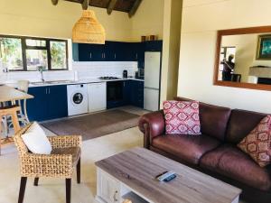 un soggiorno con divano e tavolo di Wild Rose Country Lodge a Noordhoek