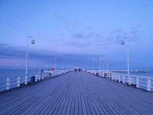 a wooden pier with people walking on it at Hotel Miramar in Sopot