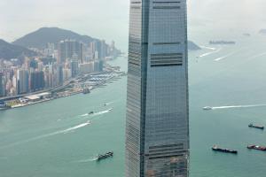 un edificio alto junto a un cuerpo de agua en The Ritz-Carlton Hong Kong, en Hong Kong