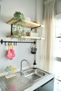 a kitchen counter with a sink and shelves at Cozy room in Khlongluang II in Khlong Luang