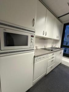 uma cozinha com armários brancos e um micro-ondas em Pension Bavaria Immobilien em Nurembergue