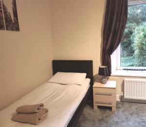 um pequeno quarto com uma cama e uma janela em 2-level apartment em Aberdeen
