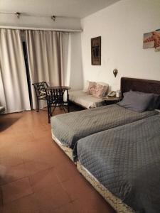 ein Schlafzimmer mit einem Bett, einem Tisch und einem Sofa in der Unterkunft Coral Bay Roby in Sharm El Sheikh