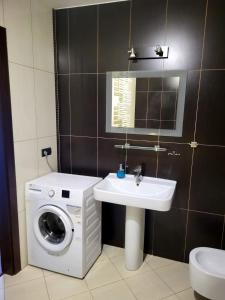 a bathroom with a washing machine and a sink at Lemuria Przytulny pokój Chojnowska in Legnica