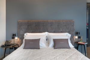 ein Schlafzimmer mit einem großen Bett mit zwei Kissen in der Unterkunft Emerald Hotel Residence Cefalù in Cefalú
