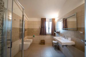 e bagno con lavandino, servizi igienici e doccia. di Agàpe Rooms in Tropea a Tropea