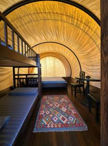 a room with bunk beds and a rug at Panorama Glamping in Tân Phú