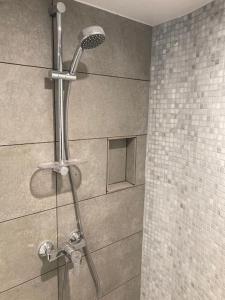La salle de bains est pourvue d'une douche avec un pommeau de douche. dans l'établissement Le petit RepOzoir, une halte entre Paris et Disney, à Ozoir-la-Ferrière
