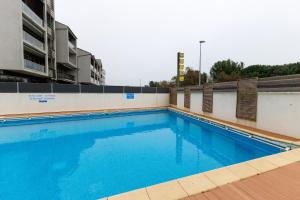 a swimming pool on the side of a building at Logis Hôtel Le Rochelois in La Rochelle
