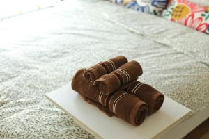 a stack of brown towels sitting on a white plate at Cozy room in Khlongluang II in Khlong Luang