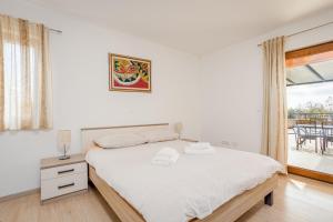 ein weißes Schlafzimmer mit einem Bett und einem Fenster in der Unterkunft Villa Ana for 12 persons with private saltwater Pool in Juršići