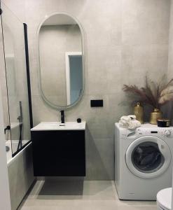 a bathroom with a washing machine and a mirror at Apartamenty Zuzanny in Mińsk Mazowiecki