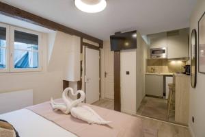 um quarto com uma cama com uma decoração de cisne em Studio 2pers # Île St Louis # Bord de Seine em Paris