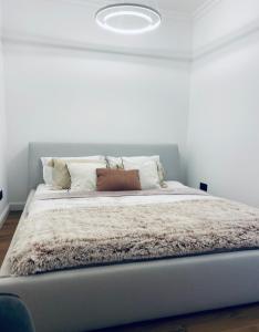 1 dormitorio con 1 cama grande y paredes blancas en Apartamenty Zuzanny, en Mińsk Mazowiecki