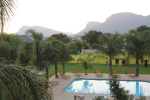 a view of a swimming pool with mountains in the background at Casa Bianca Guest Lodge in Hartbeespoort