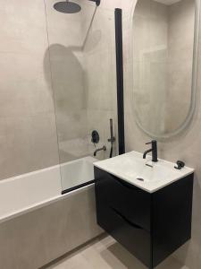 een badkamer met een wastafel en een douche bij Apartamenty Zuzanny in Mińsk Mazowiecki