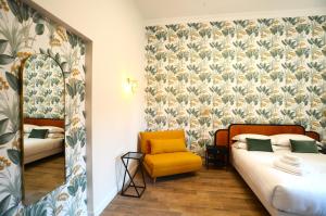 una camera con due letti e una sedia gialla di San Cosimato 40 guesthouse a Roma