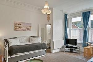 a bedroom with a bed and a television in it at Finest Retreats - Atherfield Apartments No 7 - Sunny Side in Paignton