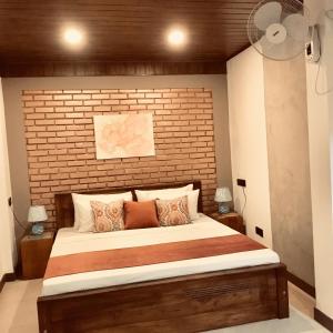 a bedroom with a large bed with a brick wall at Cinnamon Tan Residential Boutique Hotel in Negombo +45 photos