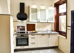 a kitchen with white cabinets and a sink at Ferienhaus Villa Heimfried Büsum in Büsum