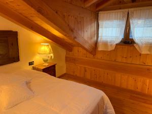 Tempat tidur dalam kamar di TROIS COURONNES B&B di Charme Appartamenti ad uso turistico VDA La Salle
