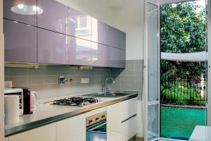 a kitchen with a sink and a stove and a window at Angels House Boccadasse Gaslini in Genova